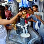 Devotees perform rituals on the occasion of Maha Shivratri festival at Shiva temple