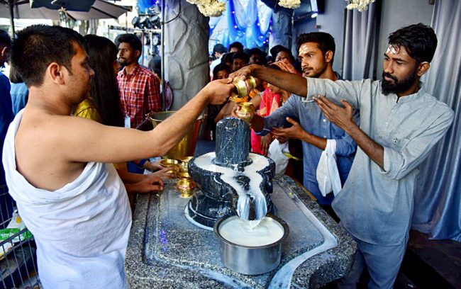 Devotees perform rituals on the occasion of Maha Shivratri festival at Shiva temple