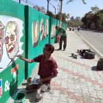 An artist makes graffiti showing a picture of USA President Donald Trump