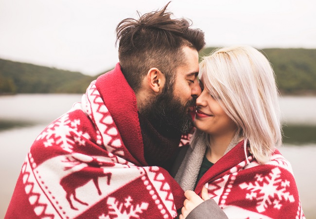 Couple kissing outside under the blanket