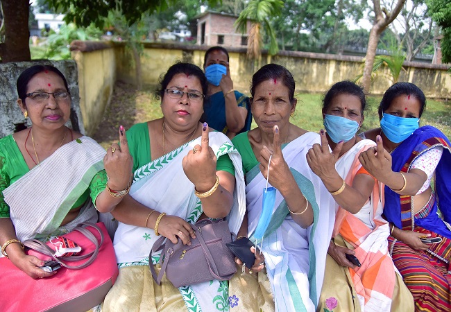 Female voters show their finger marked with indelible ink after casting a vote